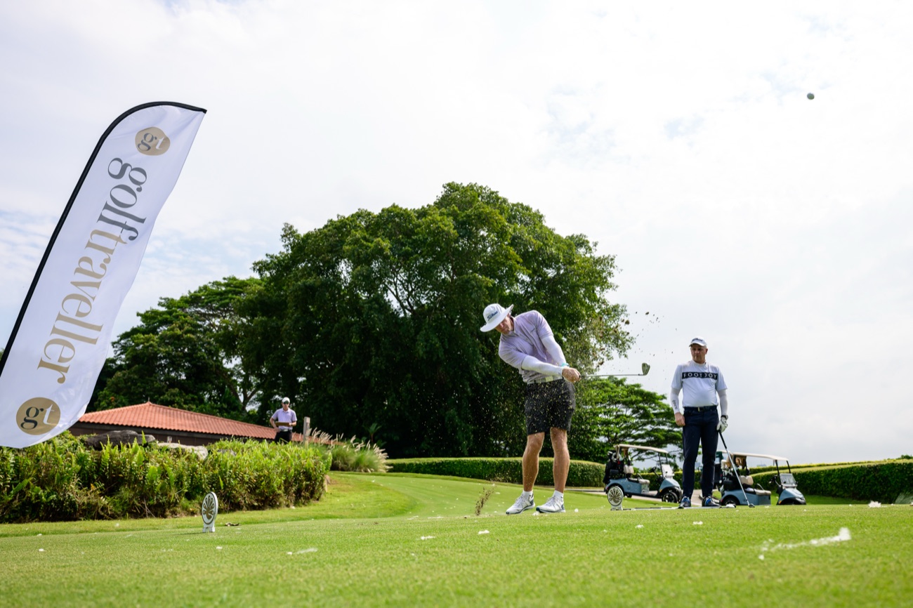 A Golf Traveller event, golfer mid-swing beside the brand flag